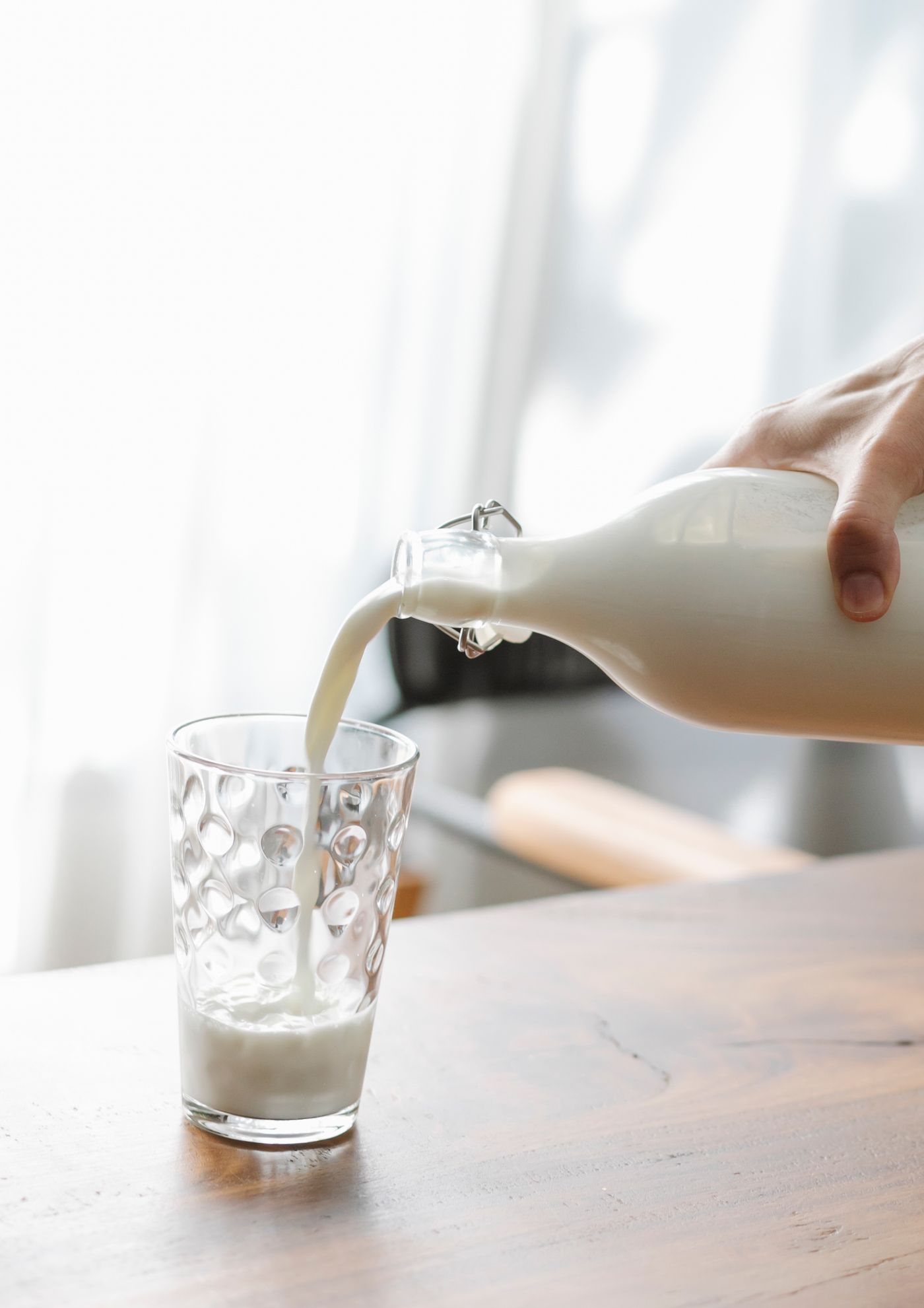 Milk being poured into a glass, a classic source of dietary calcium